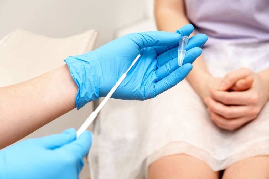 The gynecologist takes a sample of biomaterial from the patient's urogenital tract for PCR examination,hands close- up