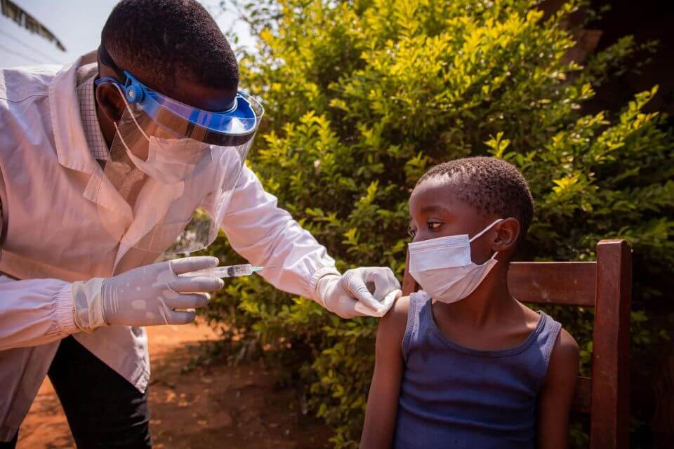 一位在非洲的医生给一个孩子接种疫苗